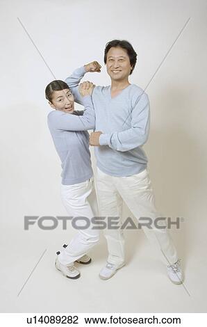 Stock Image - Mature woman hanging from mature man's arm. Fotosearch
