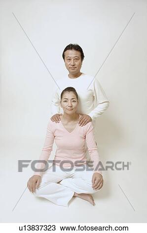 Mature woman sitting cross-legged, mature man behind her View Large Photo Image Stock Image - Mature woman sitting cross-legged, mature man behind her. Fotosearch
