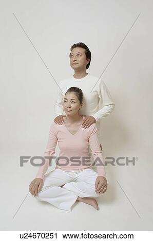 Mature woman sitting cross-legged, mature man behind her View Large Photo Image Stock Image - Mature woman sitting cross-legged, mature man behind her. Fotosearch