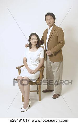Mature woman sitting in chair and mature man standing View Large Photo Image Stock Photo - Mature woman sitting in chair and mature man standing. Fotosearch