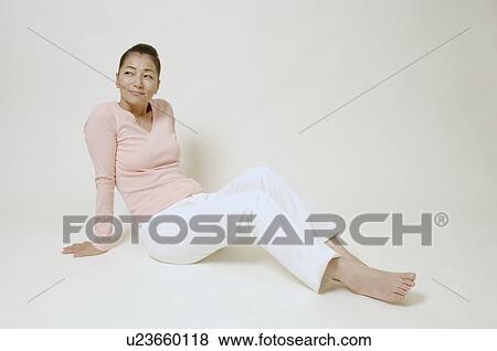 Mature woman sitting on floor View Large Photo Image Stock Photo - Mature woman sitting on floor. Fotosearch