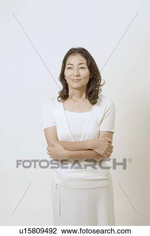 Mature woman standing with her arms crossed View Large Photo Image Stock Image - Mature woman standing with her arms crossed. Fotosearch