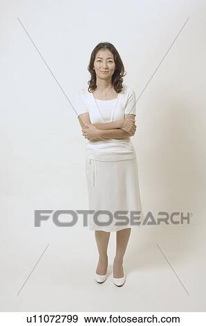 Mature woman standing with her arms crossed View Large Photo Image Stock Photo - Mature woman standing with her arms crossed. Fotosearch
