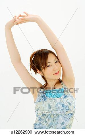 Stock Image - Young woman holding hands above head. Fotosearch