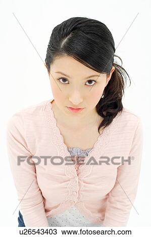 Stock Image - Young woman looking at camera. Fotosearch