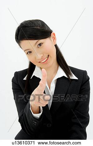 Stock Image - Young woman pointing straight ahead. Fotosearch