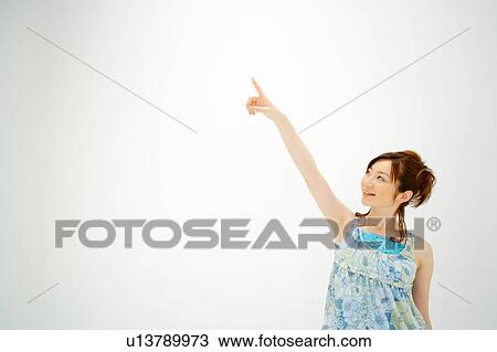 Young woman pointing up View Large Photo Image Stock Image - Young woman pointing up. Fotosearch