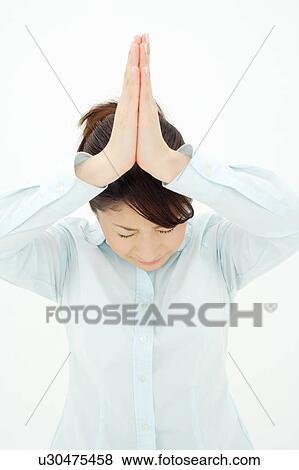 Stock Photo - Young woman praying. Fotosearch