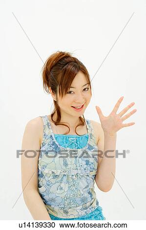 Stock Image - Young woman waving hand. Fotosearch