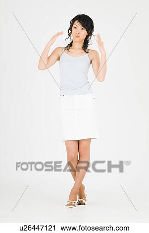 Stock Image - Young woman fanning herself with hands. Fotosearch