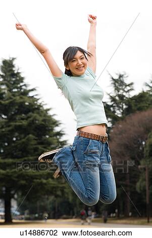 Stock Image - Young woman jumping. Fotosearch