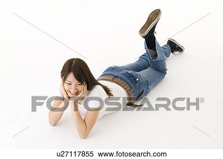 Stock Photography - Young woman lying on front smiling. Fotosearch