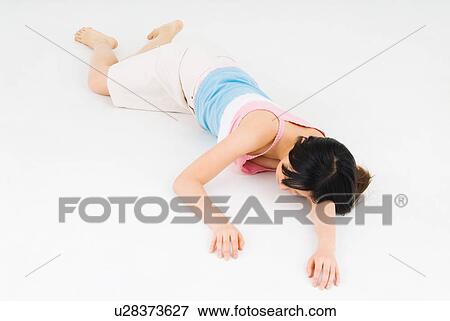 Stock Photo - Young woman lying on front. Fotosearch
