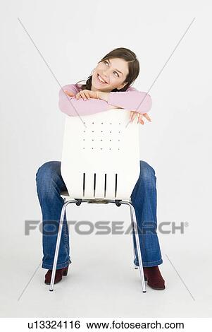 Young woman sitting backwards on chair View Large Photo Image Stock Photograph - Young woman sitting backwards on chair. Fotosearch
