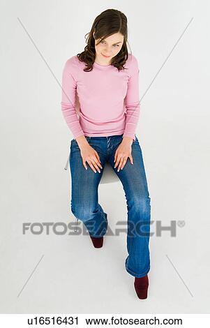 Young woman sitting on chair View Large Photo Image Stock Image - Young woman sitting on chair. Fotosearch