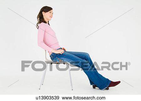Stock Photo - Young woman sitting on chair. Fotosearch