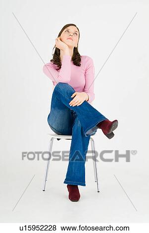 Stock Photo - Young woman sitting on chair. Fotosearch