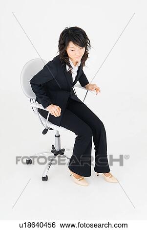 Young woman sitting on chair View Large Photo Image Stock Photograph - Young woman sitting on chair. Fotosearch