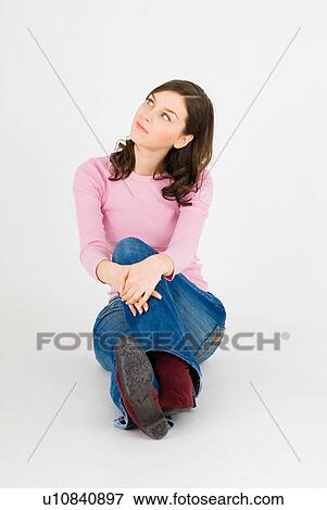 Stock Photo - Young woman sitting on floor. Fotosearch