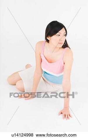 Young woman sitting on floor View Large Photo Image Stock Photo - Young woman sitting on floor. Fotosearch