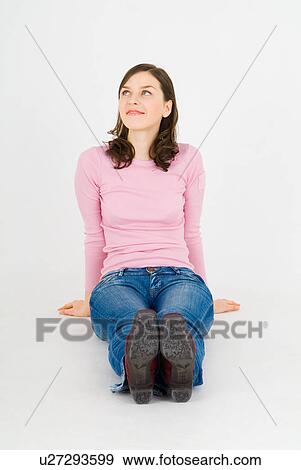 Stock Photo - Young woman sitting on floor. Fotosearch