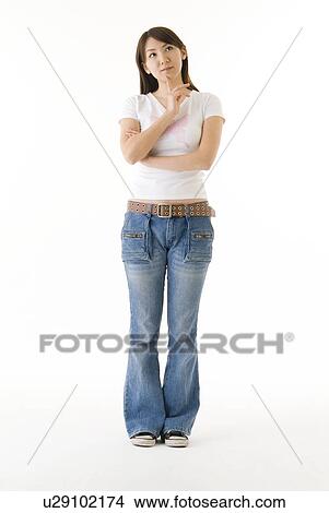 Young woman standing and thinking View Large Photo Image Picture - Young woman standing and thinking. Fotosearch