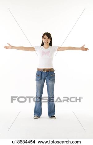 Young woman standing with arms outstretched View Large Photo Image Picture - Young woman standing with arms outstretched. Fotosearch