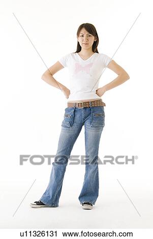 Stock Image - Young woman standing with hands on hip. Fotosearch