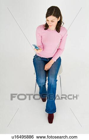 Young woman using mobile phone View Large Photo Image Stock Photograph - Young woman using mobile phone. Fotosearch