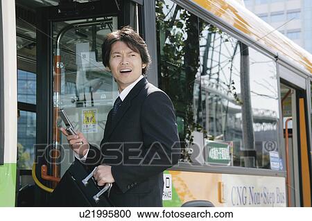 A mid adult man getting on a bus View Large Photo Image Stock Image - A mid adult man getting on a bus. Fotosearch