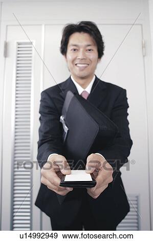 A mid adult man handing his business card View Large Photo Image Stock Photo - A mid adult man handing his business card. Fotosearch