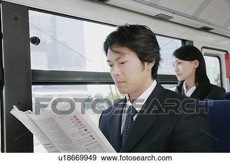A mid adult man reading newspaper in a bus View Large Photo Image Stock Photo - A mid adult man reading newspaper in a bus. Fotosearch