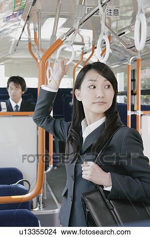 Picture - A young woman and a mid adult man in a bus. Fotosearch