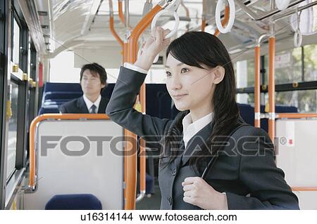 A young woman and a mid adult man in a bus View Large Photo Image Picture - A young woman and a mid adult man in a bus. Fotosearch
