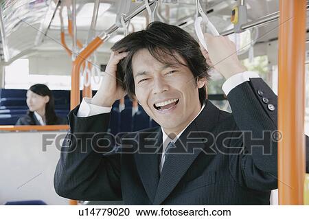 Stock Image - A young woman and a mid adult man in a bus. Fotosearch