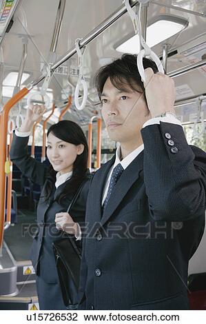 A young woman and a mid adult man standing in a bus View Large Photo Image Stock Image - A young woman and a mid adult man standing in a bus. Fotosearch