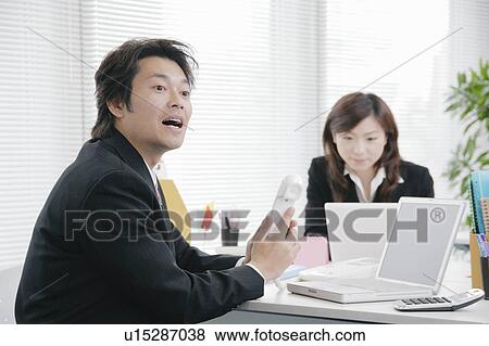 Mid adult man answering phone and calling somebody View Large Photo Image Stock Photo - Mid adult man answering phone and calling somebody. Fotosearch