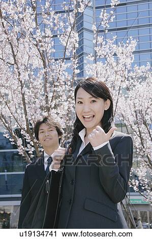 Young woman and mid adult man standing in front of cherry blossoms View Large Photo Image Stock Image - Young woman and mid adult man standing in front of cherry blossoms. Fotosearch