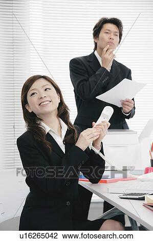 Stock Image - Young woman answering phone and calling somebody. Fotosearch