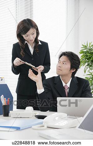 Young woman handing document to her boss View Large Photo Image Stock Photo - Young woman handing document to her boss. Fotosearch