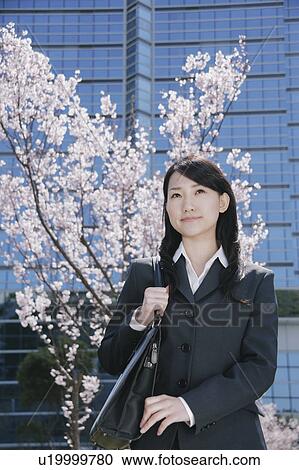 Young woman in suit standing in front of cherry blossoms View Large Photo Image Stock Image - Young woman in suit standing in front of cherry blossoms. Fotosearch