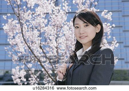 Young woman in suit standing in front of cherry blossoms View Large Photo Image Stock Photograph - Young woman in suit standing in front of cherry blossoms. Fotosearch