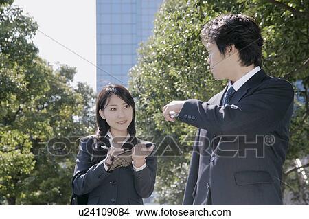 A mid adult businessman and a young businesswoman talking View Large Photo Image Picture - A mid adult businessman and a young businesswoman talking. Fotosearch