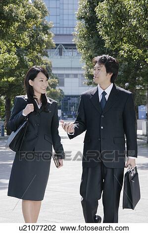 A mid adult businessman and a young businesswoman talking View Large Photo Image Stock Image - A mid adult businessman and a young businesswoman talking. Fotosearch