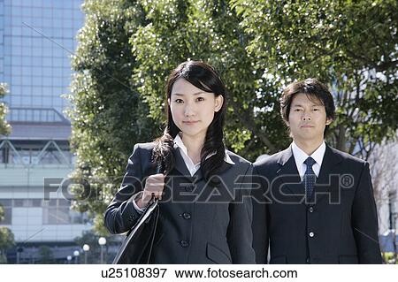 A mid adult businessman and a young businesswoman standing View Large Photo Image Stock Photo - A mid adult businessman and a young businesswoman standing. Fotosearch