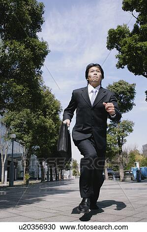 A mid adult businessman running View Large Photo Image Stock Image - A mid adult businessman running. Fotosearch