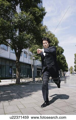 A mid adult businessman running View Large Photo Image Stock Photo - A mid adult businessman running. Fotosearch
