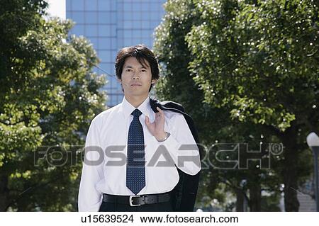 Picture - A mid adult businessman standing. Fotosearch