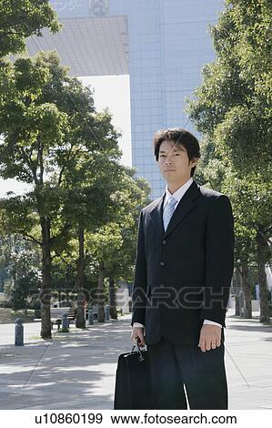 Stock Photo - A mid adult businessman standing. Fotosearch