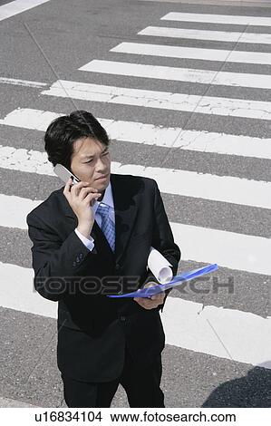 A mid adult businessman talking over a mobile phone View Large Photo Image Picture - A mid adult businessman talking over a mobile phone. Fotosearch